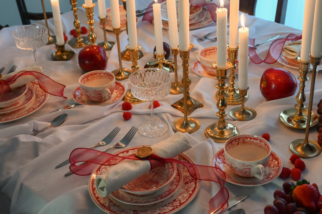 Table scape with candles, plates, silverware, stemware and table cloth