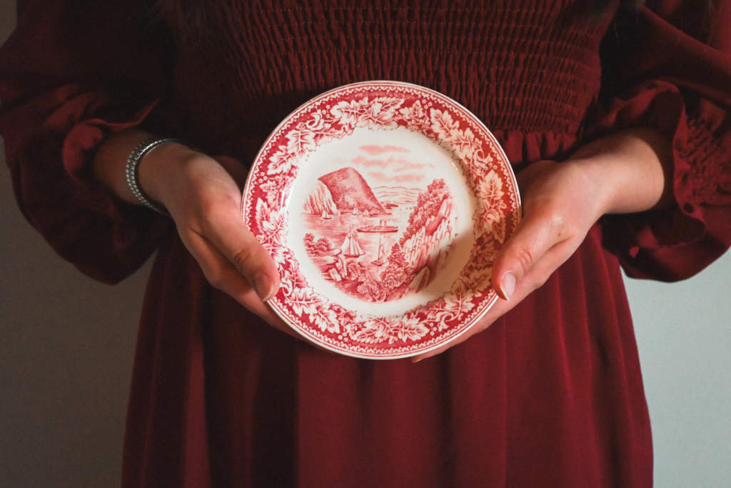 Woman in red dress holding pink and white plate