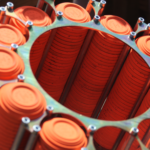 Close-up of stacks of bright orange clay pigeons loaded into an automatic trap shooting launcher