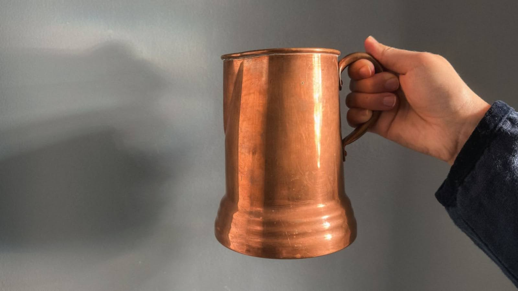 Copper pitcher against cool blue wall