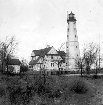 The historic white octagonal North Point Lighthouse with a red-roofed keeper's quarters in Milwaukee, Wisconsin.