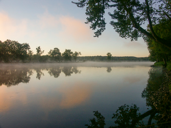 Fog rolling over the St. Croix river during sunrise.