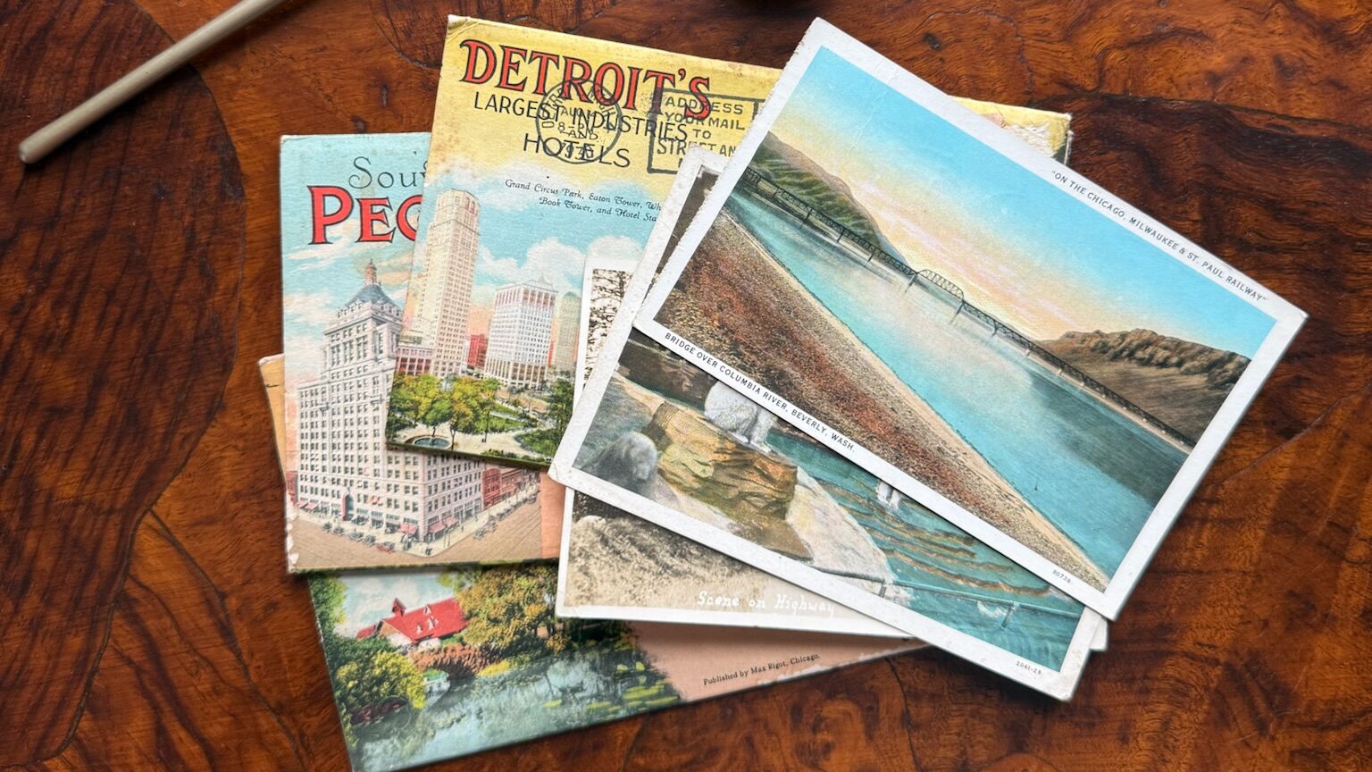 Vintage postcards set against a dark hardwood desk
